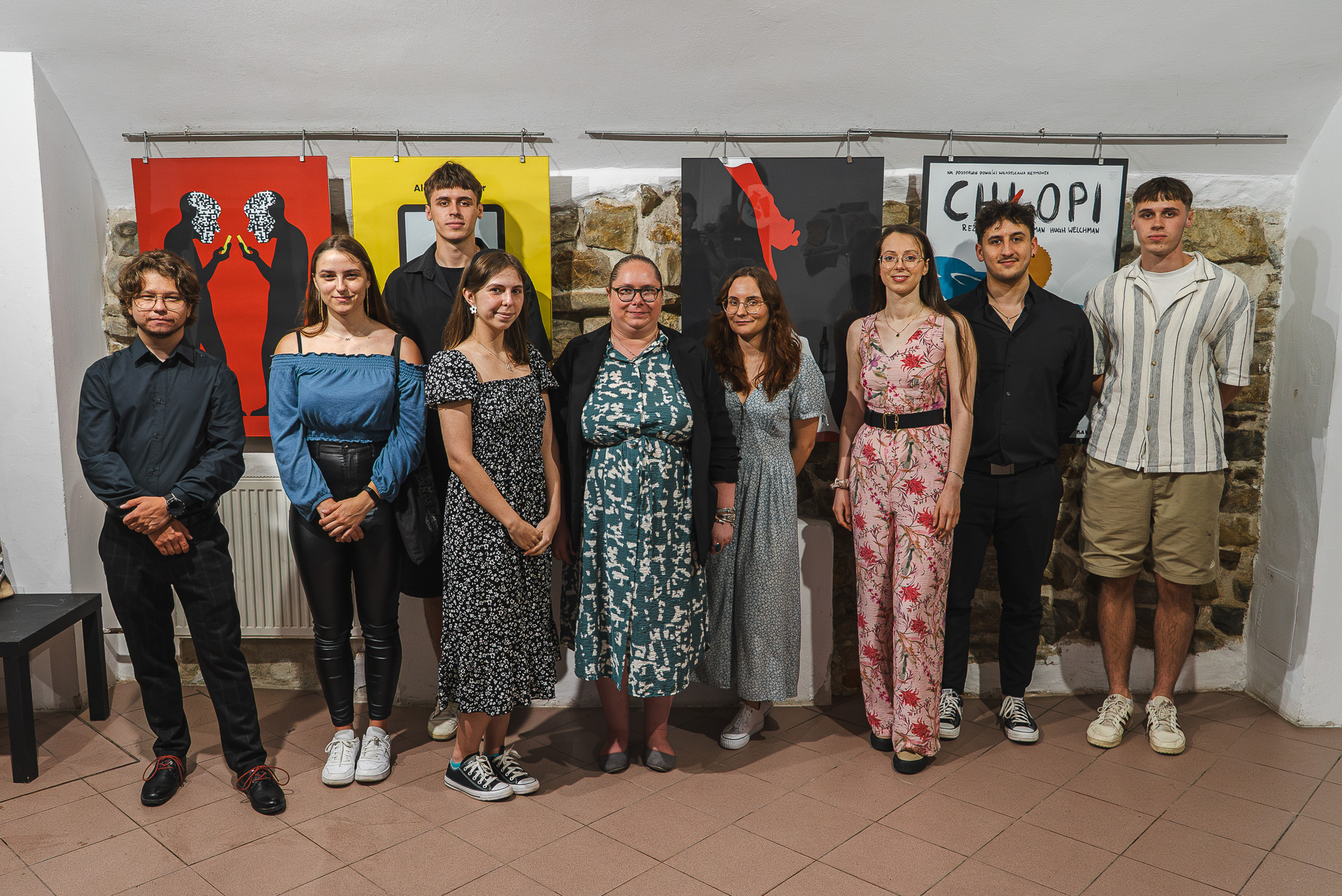Grupa młodych artystów z WSIiZ, których plakaty można zobaczyć na wystawie w Galerii pod Ratuszem wraz z kuratorem wystawy prof. Patrycją Longawą.