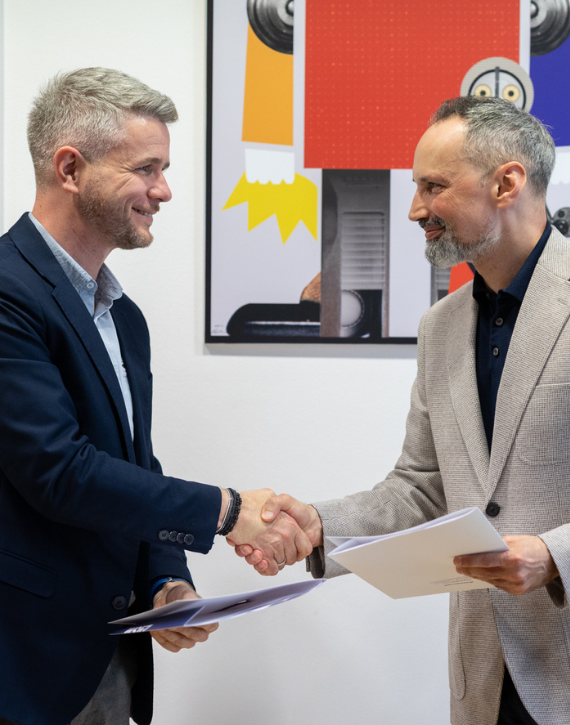 Marcin Dziedzic z Estrady Rzeszowskiej i Rektor WSIiZ wymieniają uściski