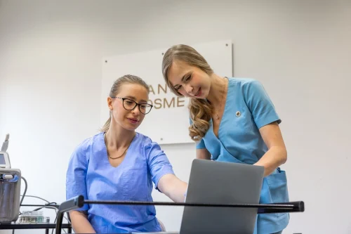 Dwie kobiety w niebieskich fartuchach kosmetycznych