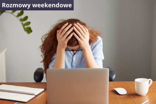 Kobieta siedzi przed laptopem i trzyma się za głowę