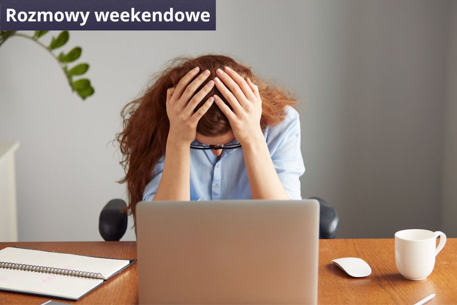 Kobieta siedzi przed laptopem i trzyma się za głowę