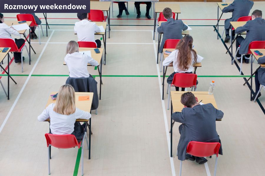 Uczniowie siedzą przy stolikach i piszą egzamin